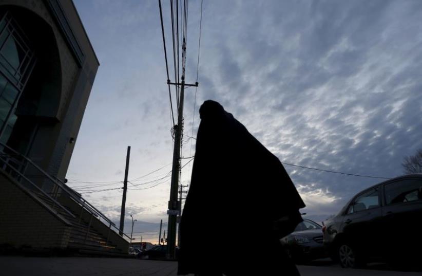 A woman walks to a mosque for evening prayer in Montreal, November 18, 2015. (photo credit: REUTERS)