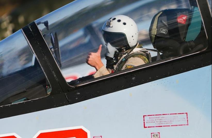 A Russian pilot gives the thumbs-up sign on an airbase in Syria (photo credit: RUSSIAN ARMED FORCES)