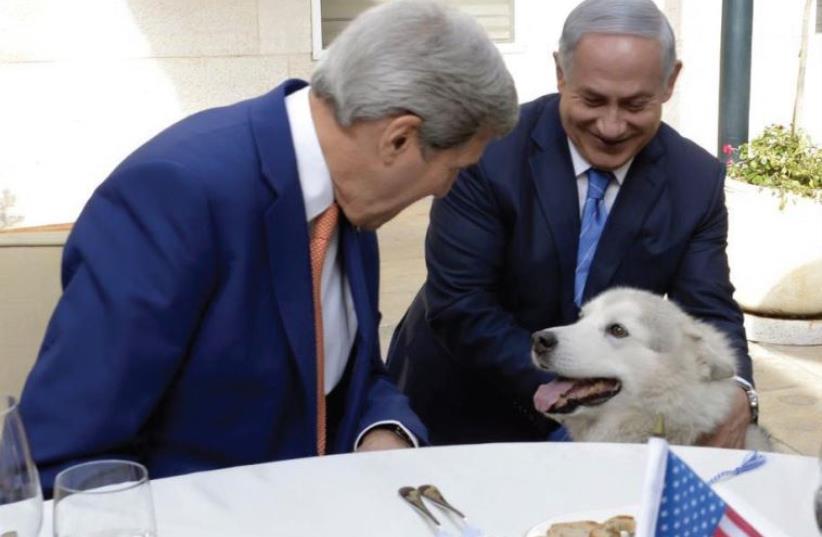 US SECRETARY of State John Kerry (L) and Prime Minister Benjamin Netanyahu lavish attention on Kaya, the prime minister’s dog (photo credit: US STATE DEPARTMENT)