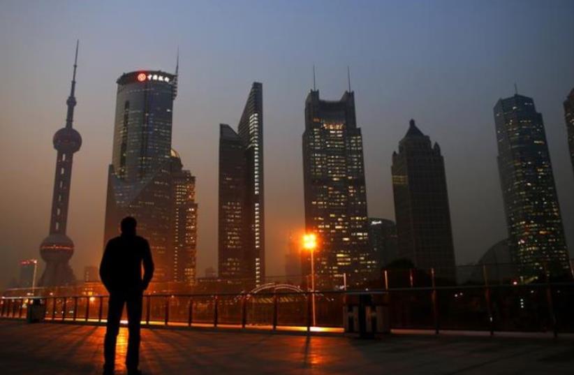 A man looks at the Pudong financial district of Shanghai November 20, 2013. (photo credit: REUTERS)