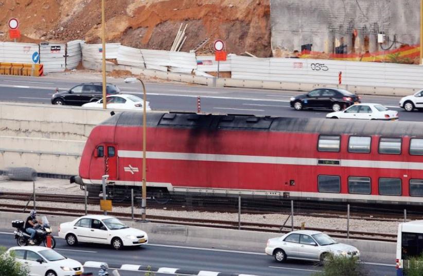 A train runs parallel to the Ayalon Highway in Tel Aviv (photo credit: MARC ISRAEL SELLEM/THE JERUSALEM POST)