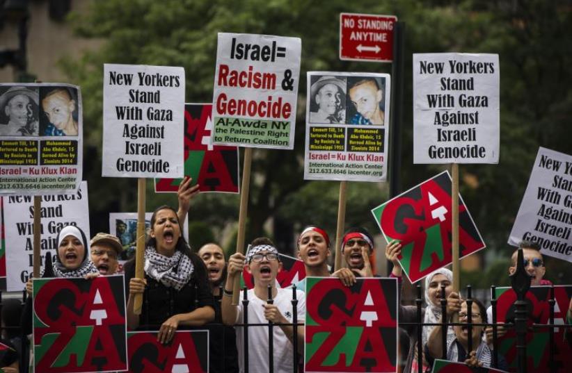 Pro-Palestinian demonstrators display signs outside of New York City hall, where a pro-Israel rally was organised (photo credit: LUCAS JACKSON / REUTERS)