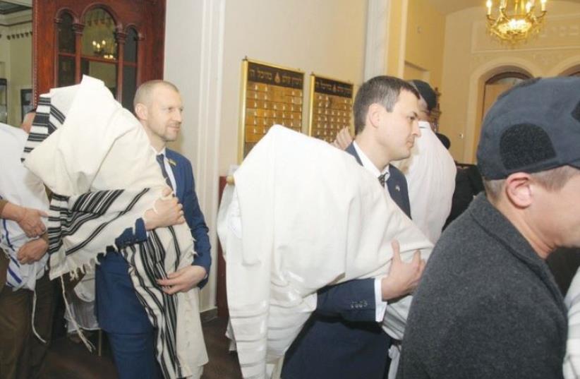 UKRAINIAN OFFICIALS return the Torah scrolls to the Brodsky Choral Synagogue in Kiev on Thursday. (photo credit: ROMAN VILENSKI)