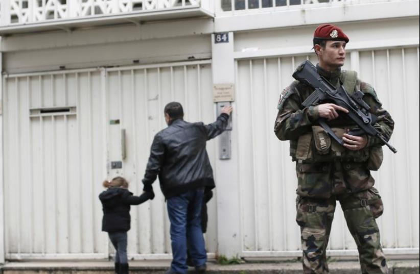A French soldier secures the entrance to a Jewish school in Paris after the Charlie Hebdo and Hyper Cacher terrorist attacks last January (photo credit: REUTERS)