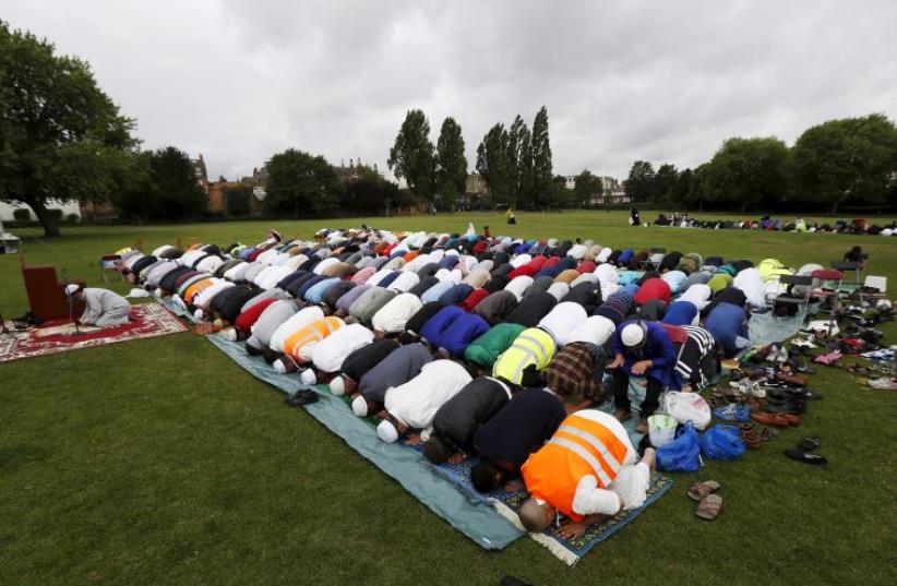 Muslims perform prayers for Eid-al Fitr to mark the end of the holy fasting month of Ramadan at a park in London (photo credit: REUTERS)