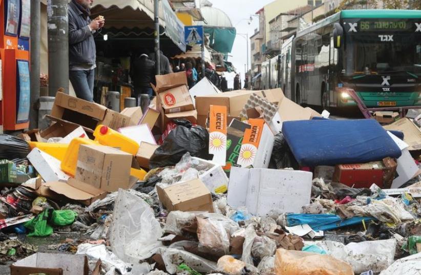 GARBAGE PILES UP on Agrippas Street just outside the Mahaneh Yehuda Market in the capital yesterday. (photo credit: MARC ISRAEL SELLEM/THE JERUSALEM POST)