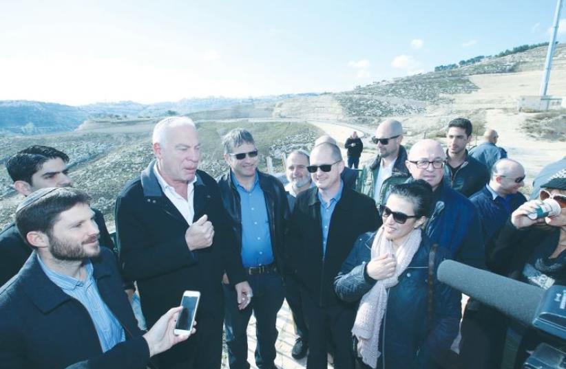 AGRICULTURE MINISTER Uri Ariel speaks at the E1 site in Ma’aleh Adumim yesterday, surrounded by members of the Knesset’s Land of Israel Caucus. (photo credit: MIRI TZAHI)