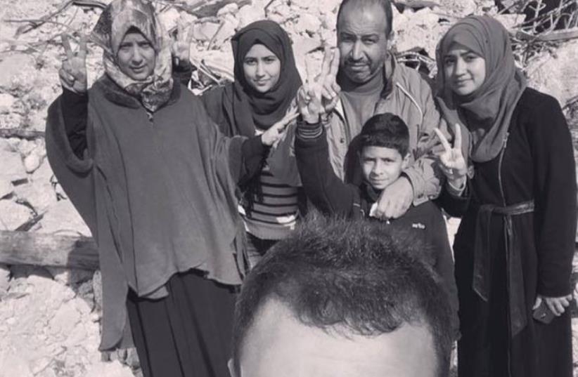 Family of Palestinian who carried out stabbing attack smiles in selfie at site of the ruins of their home, demolished by the IDF (photo credit: ARAB MEDIA)