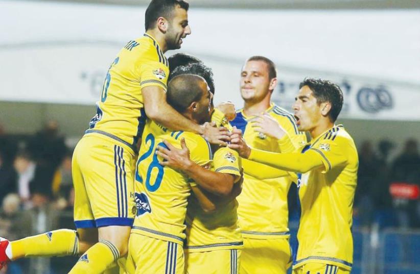 Maccabi Tel Aviv players celebrate after securing their place in the State Cup last-16 (photo credit: ADI AVISHAI)