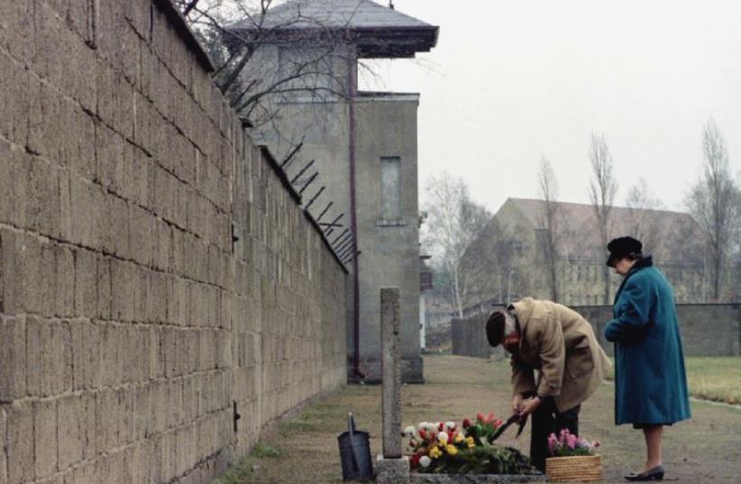 An elderly couple lays a wreath in front of a memorial for the victims of the Nazi concentration camp in Sachsenhausen (photo credit: REUTERS)