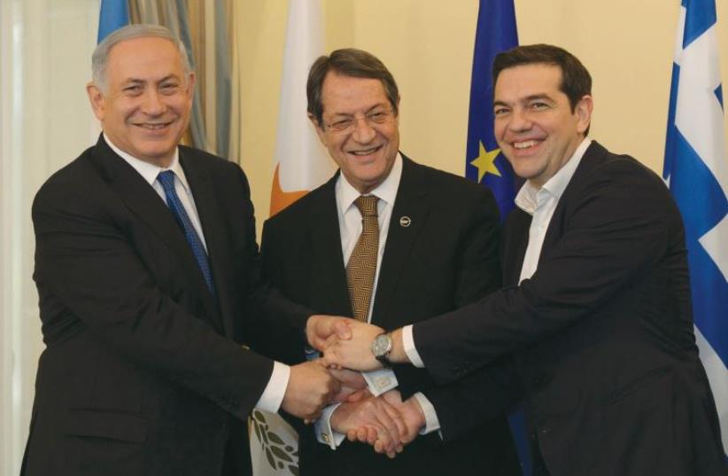 PRIME MINISTER Benjamin Netanyahu, Cypriot President Nicos Anastasiades (center) and Greek Prime Minister Alexis Tsipras shake hands ysterday outside the Presidential Palace in Nicosia, Cyprus, January 28, 2013 (photo credit: HAIM ZACH/GPO)