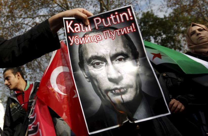 Pro-Islamist demonstrators set fire to a defaced poster of Russia's President Vladimir Putin during an anti-Russian protest in Istanbul (photo credit: REUTERS)
