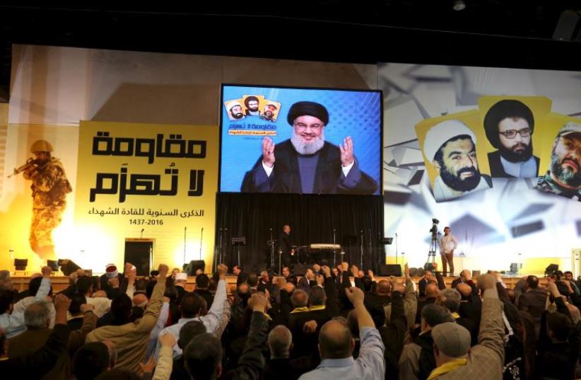 Lebanon's Hezbollah leader Sayyed Hassan Nasrallah addresses his supporters through a giant screen during a rally commemorating the annual Hezbollah Martyrs' Leader Day in Beirut's southern suburbs, Lebanon February 16, 2016 (photo credit: REUTERS)