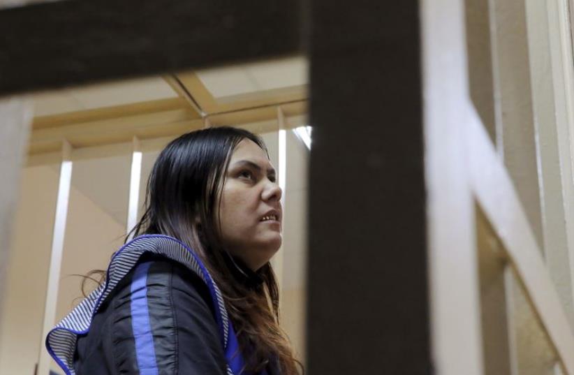 Gulchekhra Bobokulova, a nanny suspected of murdering a child in her care, looks on inside a defendants' cage as she attends a court hearing in Moscow, Russia, March 2, 2016.  (photo credit: REUTERS)