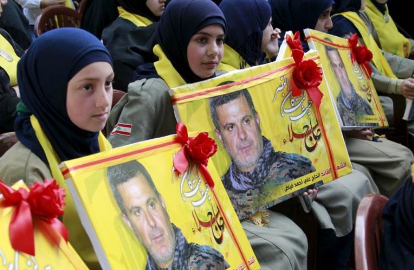 Lebanon's Hezbollah al-Mahdi girl scouts carry pictures of Ali Fayyad, a senior commander who was killed fighting alongside Syrian army forces in Syria (photo credit: REUTERS)