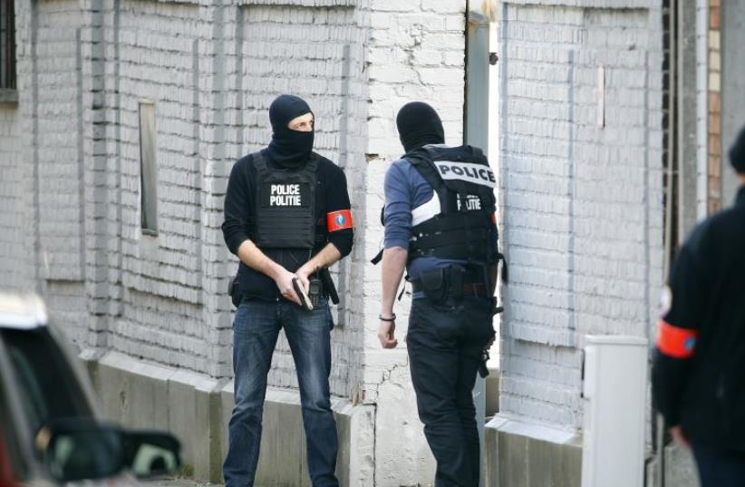 Police at the scene where shots were fired during a police search of a house in the suburb of Forest near Brussels, Belgium, March 15, 2016. (photo credit: REUTERS)
