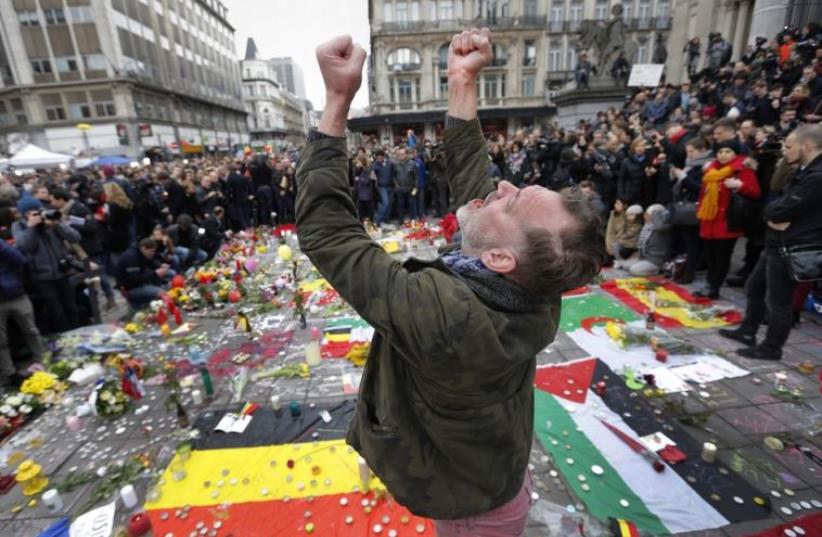 A man reacts at a street memorial following Tuesday's bomb attacks in Brussels (photo credit: REUTERS)