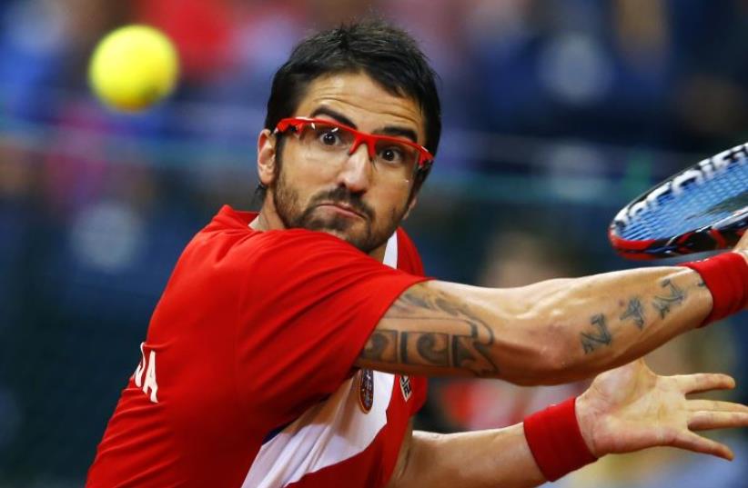 Serbia's Janko Tipsarevic returns the ball to Canada's Vasek Pospisil during their Davis Cup semi-final tennis match in Belgrade September 15, 2013. (photo credit: REUTERS)