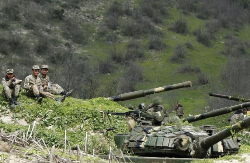 SERVICEMEN OF the army of Nagorno-Karabakh rest at their positions near the village of Mataghis, yesterday. (photo credit: REUTERS)