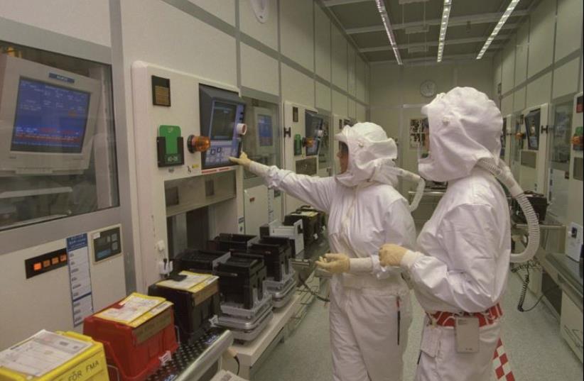 Technicians in sterile suits supervise the manufacture of computer chips in Intel’s factory in Jerusalem (photo credit: AVI OHAYON - GPO)