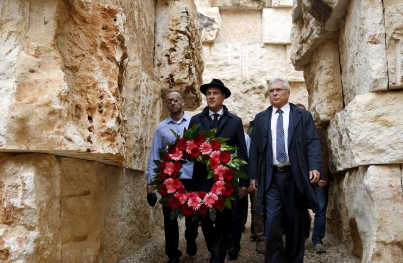 Head of the Austrian Freedom Party (FPOe) Heinz-Christian Strache (C) holds a wreath during a ceremony at "The Valley of the Communities" monument in Yad Vashem (photo credit: REUTERS)