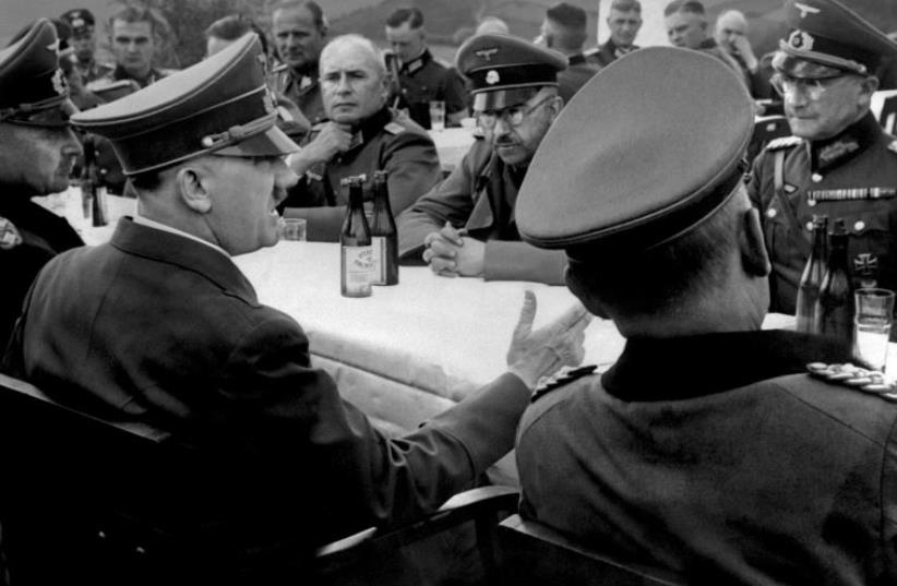 A picture dated 1939 shows German nazi Chancellor and dictator Adolf Hitler (4th L, no uniform) having a drink with high rank officers of his general staff including Heinrich Himmler (background, glasses and moustache) during a military campaign at the beginning of World War II. (photo credit: AFP PHOTO)