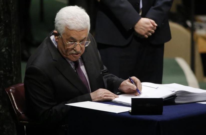 Palestinian Authority President Mahmoud Abbas signs the Paris Agreement on climate change at UN headquarters in New York (photo credit: REUTERS)