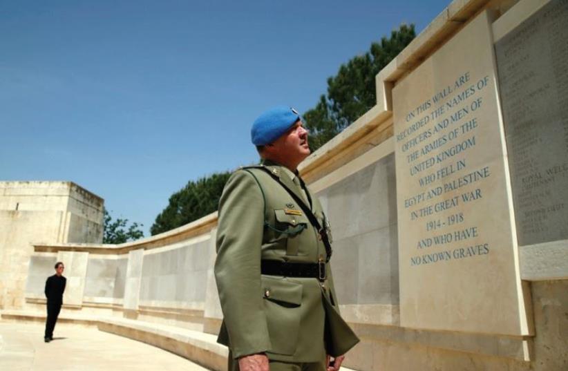 AN OFFICER reads the inscription on the Tomb of the Unknown Soldier memorial at the Mount Scopus Commonwealth War Graves Cemetery yesterday, ANZAC Day. (photo credit: REUTERS)