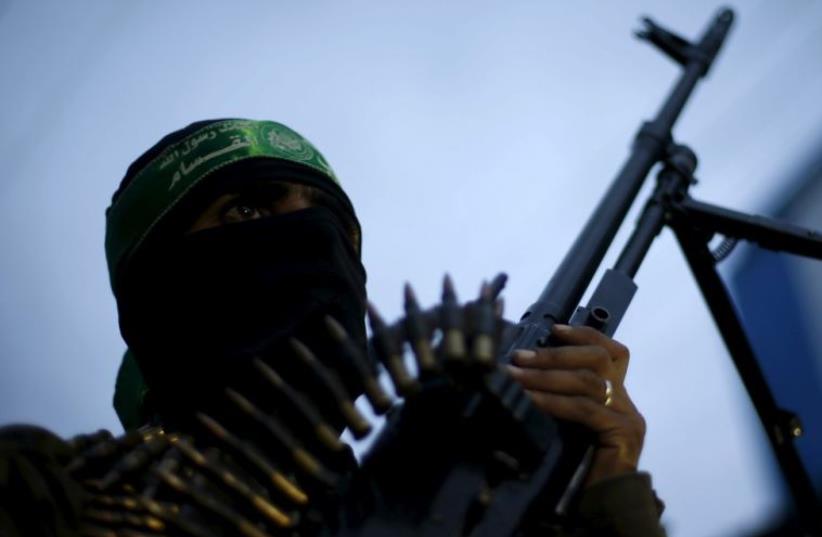 A Palestinian Hamas militant takes part in a rally marking the twelfth anniversary of the death of late Hamas leader Sheikh Ahmed Yassin in Gaza City (photo credit: REUTERS)