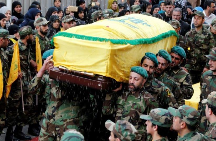 Rice is thrown as Hezbollah members carry the coffin of top Hezbollah commander Mustafa Badreddine (photo credit: REUTERS)