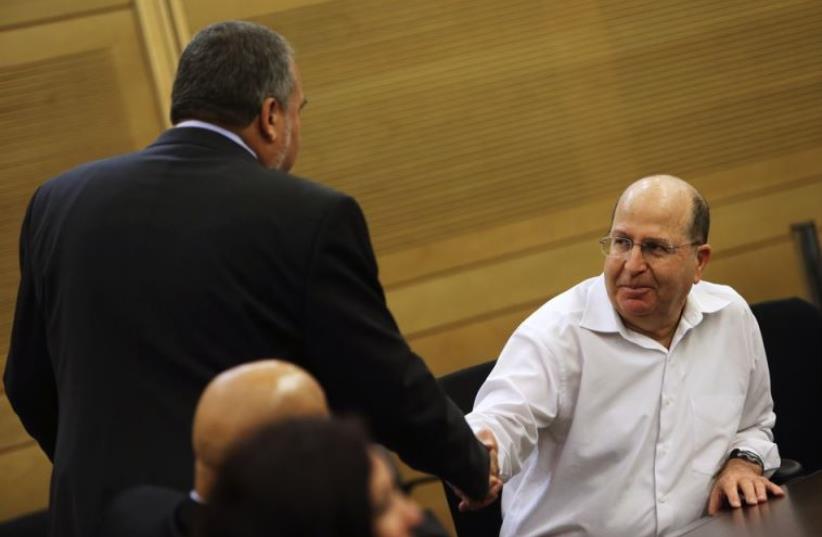 Moshe Ya'alon (R) shakes hands with Avigdor Liberman at the Knesset in Jerusalem (photo credit: REUTERS)