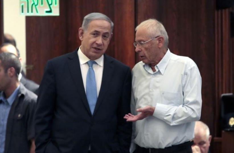 Prime Minister Benjamin Netanyahu (L) and Bennie Begin confer in the Knesset (photo credit: AFP PHOTO)