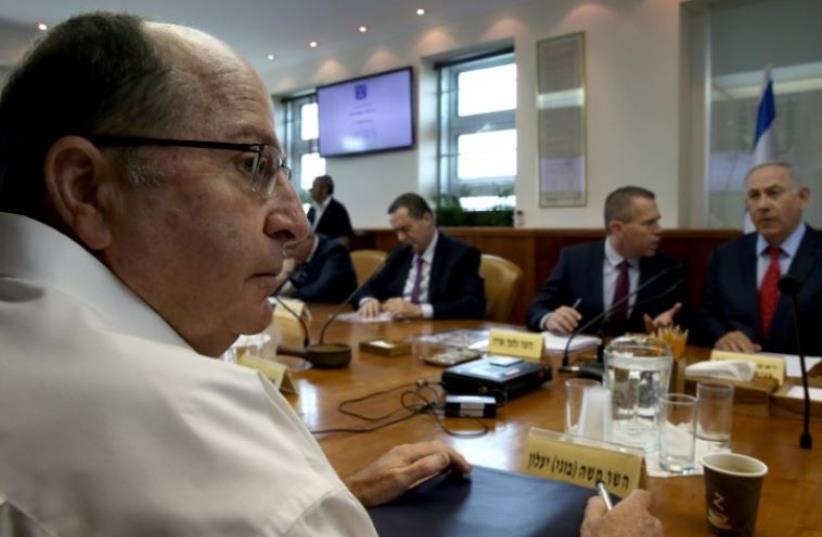 Defense Minister Moshe Yaalon (L) takes part in the weekly cabinet meeting chaired by Prime Minister Benjamin Netanyahu (R) (photo credit: AFP PHOTO)