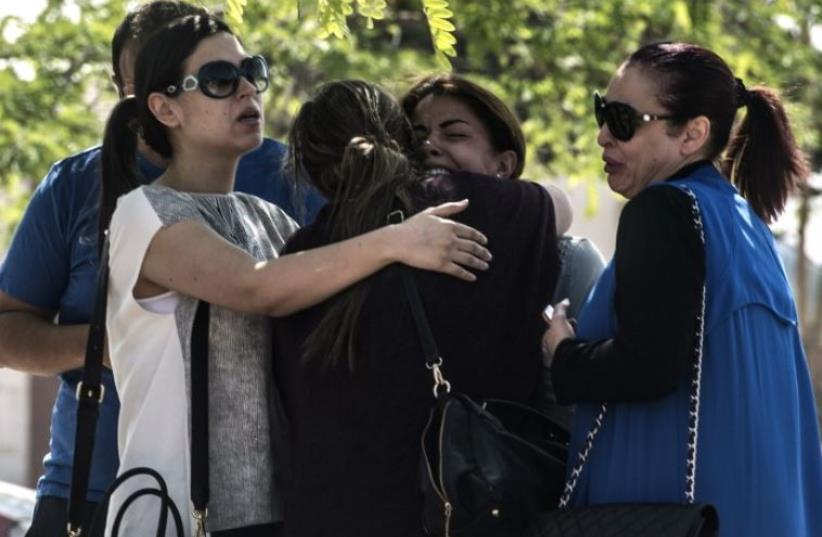 Families of passengers who were flying in an EgyptAir plane that vanished from radar en route from Paris to Cairo react as they wait outside a services hall at Cairo airport (photo credit: AFP PHOTO)