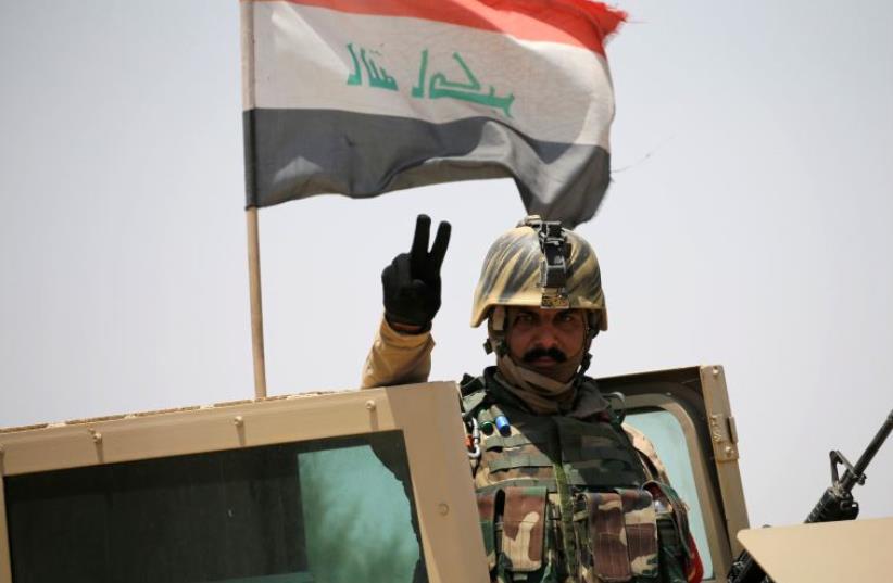 An Iraq soldier gestures near Falluja, Iraq (photo credit: REUTERS)