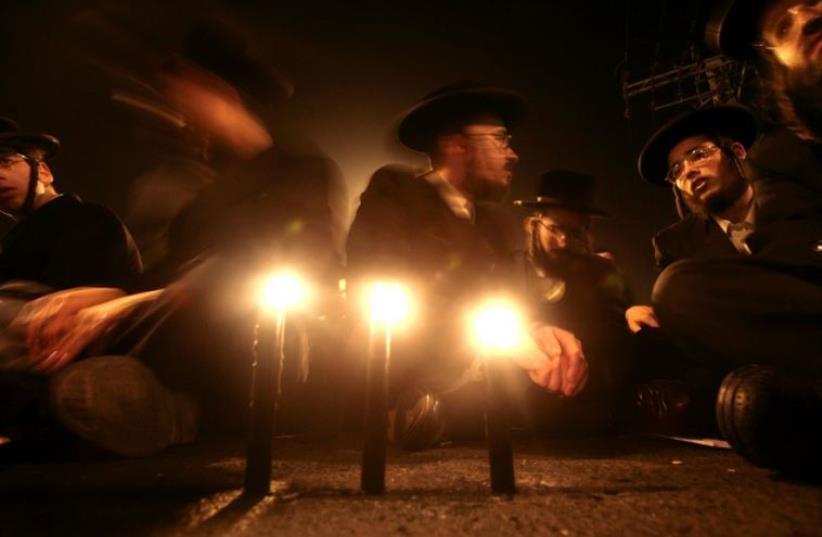 Ultra-Orthodox Jews light candles in Jerusalem (photo credit: REUTERS)