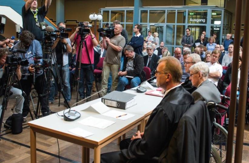 JOURNALISTS TAKE pictures of defendant Reinhold Hanning, a 94-year-old former guard at the Auschwitz death camp, before his verdict in Detmold, Germany. (photo credit: REUTERS)