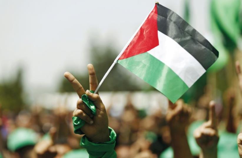 A student supporting Hamas holds a Palestinian flag in a rally in Ramallah, earlier this year (photo credit: REUTERS)