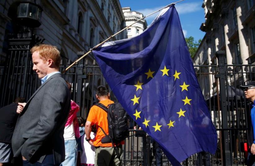 A man carries a EU flag, after Britain voted to leave the European Union (photo credit: REUTERS)