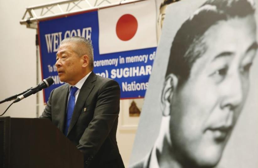 NOBUKI SUGIHARA, son of Japanese diplomat, Chiune Sugihara (in black and white picture), who helped save thousands of Lithuanian Jews in World War II, speaks during a street-naming ceremony in honor of his father in Netanya, earlier this month. (photo credit: REUTERS/BAZ RATNER)