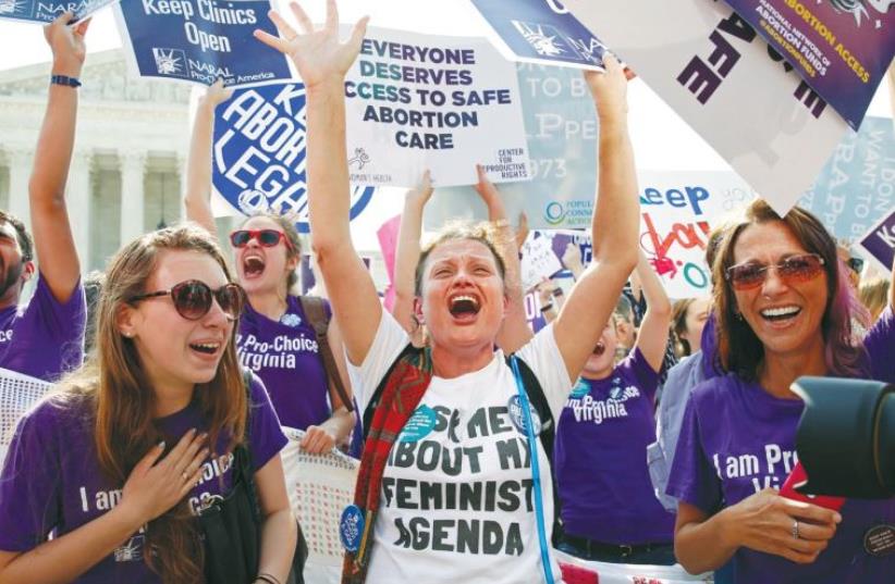DEMONSTRATORS CELEBRATE at the US Supreme Court in Washington on Monday after the justices struck down a Texas law designed to restrict abortion. (photo credit: KEVIN LAMARQUE/REUTERS)