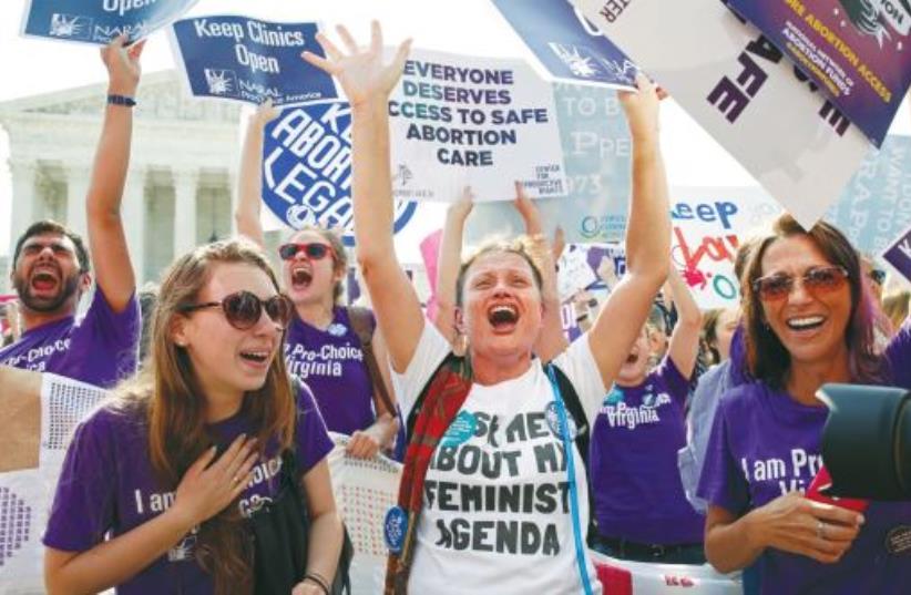 DEMONSTRATORS CELEBRATE at the US Supreme Court in Washington on Monday after the justices struck down a Texas law designed to restrict abortion. (photo credit: KEVIN LAMARQUE/REUTERS)