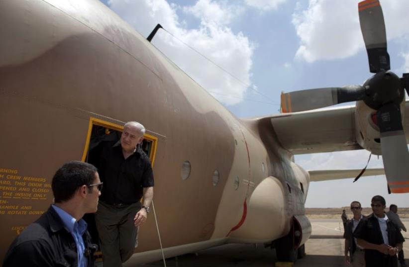 Prime Minister Benjamin Netanyahu during a visit to Hatzerim air base exits a C-130 Hercules aircraft used in the rescue of Israeli hostages at Entebbe in 1976. (photo credit: URIEL SINAI/POOL/REUTERS)