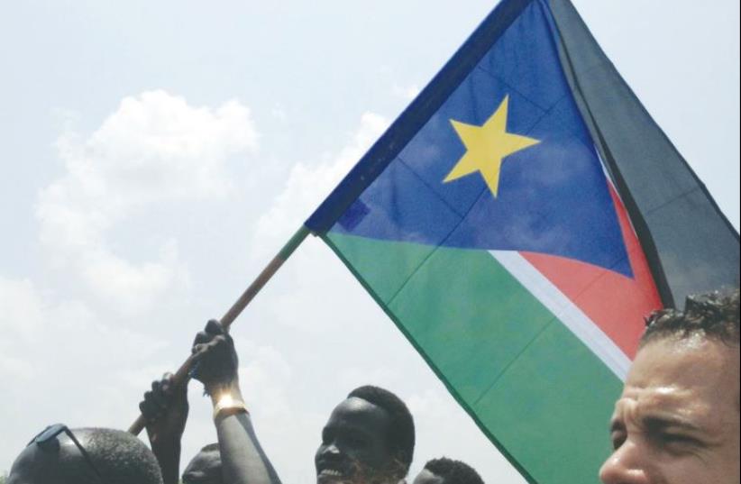 A PROUD CITIZEN waves the South Sudan flag at a pro-government demonstration on Monday, the same day the Israel Forum for International Humanitarian Aid (IsraAID) became trapped by the local internecine conflict. (photo credit: ISRAAID)