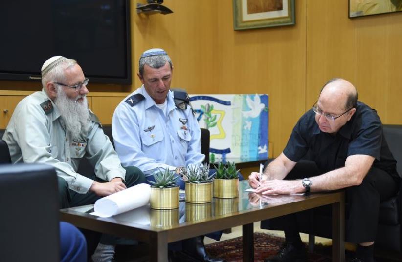 Rabbi Col. Eyal Karim (left), nominated to become IDF chief rabbi, sits next to his predecessor, Bri (photo credit: DEFENSE MINISTRY/DIANA HANANSHIVILI)