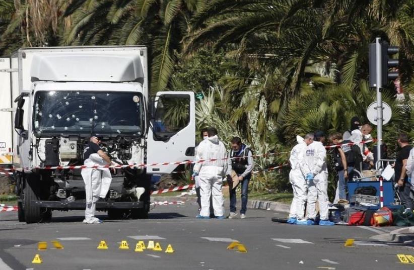 Investigators continue at the scene near the heavy truck that ran into a crowd at high speed killing scores who were celebrating the Bastille Day July 14 national holiday on the Promenade des Anglais in Nice, France, July 15, 2016.  (photo credit: REUTERS/ERIC GAILLARD)