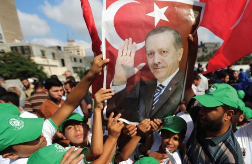 PALESTINIANS HOLD a poster of President Tayyip Erdogan during a demonstration yesterday in Gaza in support of the Turkish government. (photo credit: REUTERS)
