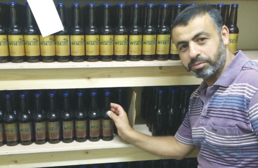 RAFAT HOUARY shows off his Wise Men Choice spiced ales brewed in Beit Sahour. (photo credit: ADAM RASGON)