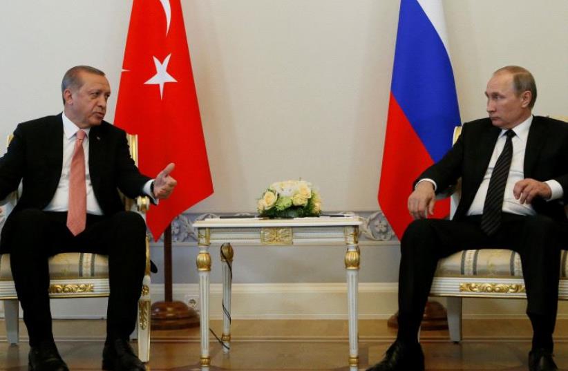 Turkish President Tayyip Erdogan speaks to Russian President Vladimir Putin (R) during their meeting in St. Petersburg, Russia, August 9, 2016 (photo credit: REUTERS)