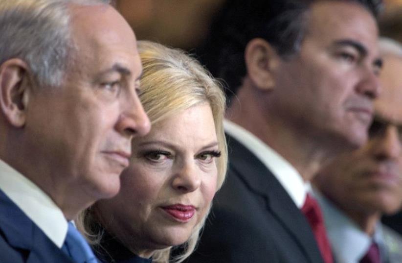 Sara Netanyahu sitting next to Prime Minister Benjamin Netanyahu  (photo credit: BRENDAN SMIALOWSKI / AFP)